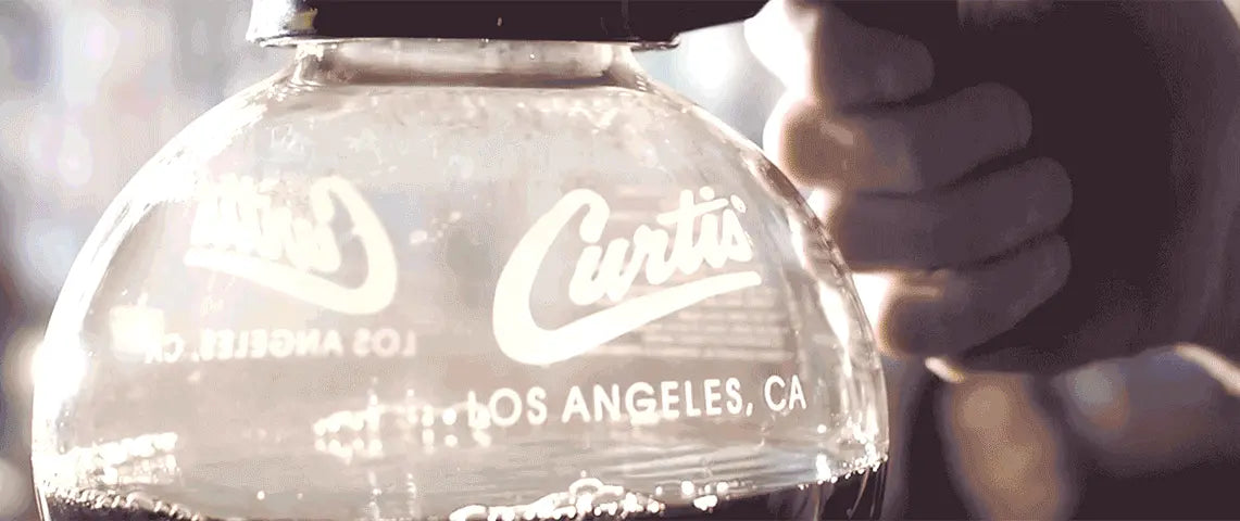A person holds the iconic Curtis Filter Coffee Flask